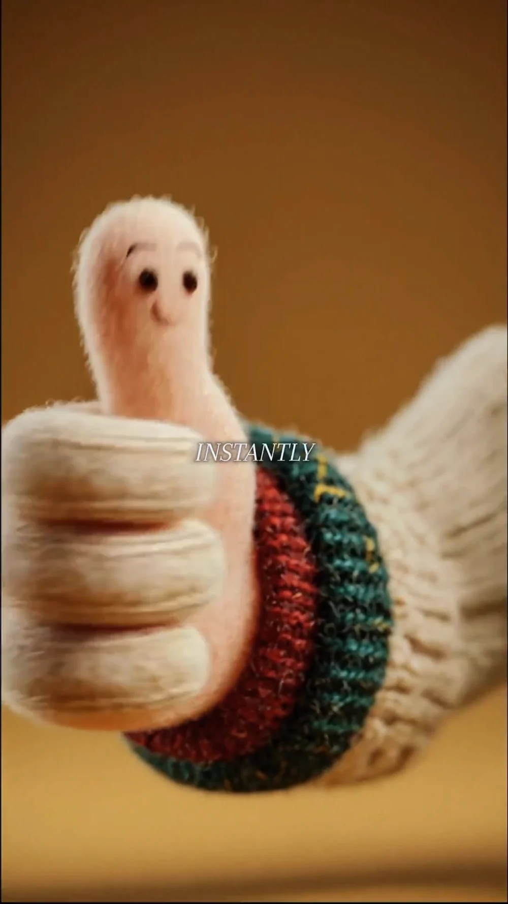 A knitted hand giving a thumbs-up.