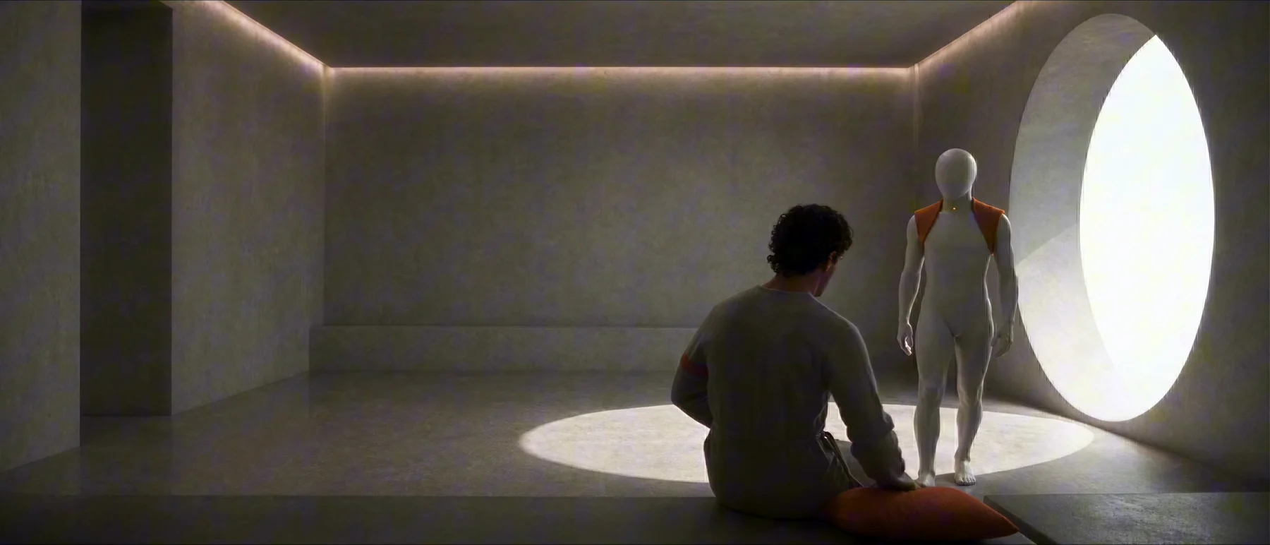 A bare room lit by one round window.